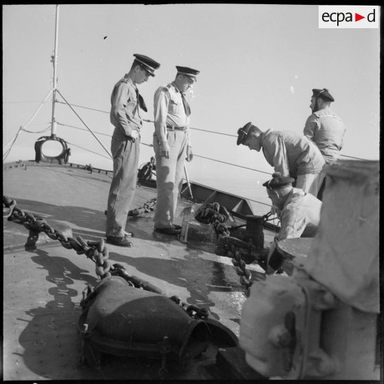 Déroulement de l'ancre par des matelots surveillée par un aspirant de marine sur l'escorteur Hova lors de la manoeuvre de mouillage.