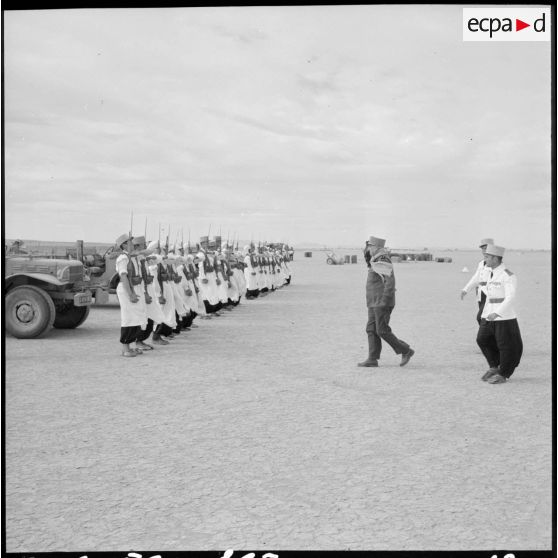 Arrivée du général Balmitgère devant la garde d'honneur du 2e peloton de la compagnie méhariste du Tassili (CMT) à l'aérodrome de Fort Polignac.