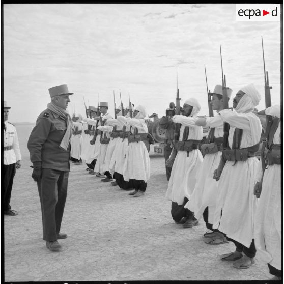 Le général Balmitgère passe en revue la garde d'honneur du 2e peloton de la compagnie méhariste du Tassili (CMT) à l'aérodrome de Fort Polignac.