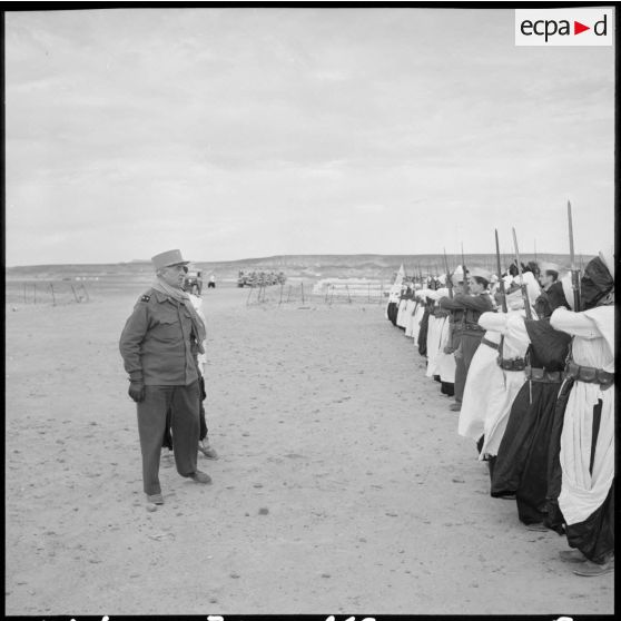 Le général Balmitgère passe en revue la garde d'honneur du 2e peloton de la compagnie méhariste du Tassili (CMT) sur l'aérodrome de Fort Polignac.