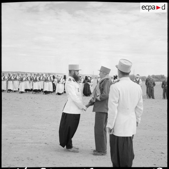 Poignée de main entre un lieutenant de la compagnie méhariste du Tassili (CMT) et le général Balmitgère à l'aérodrome de Fort Polignac.