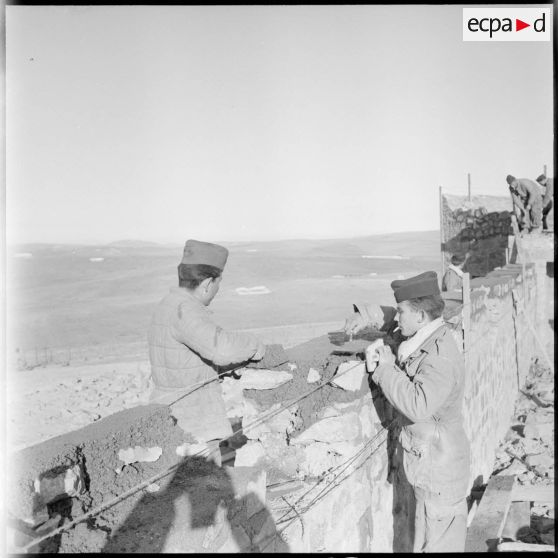 Construction du mur d'un poste frontière au sud-ouest de Nemours pas deux soldats du 2e régiment de spahis algériens (2e RSA).