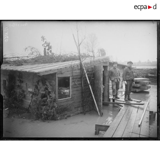 Près de Westvleteren. Soldats belges à la;porte de leur cagna inondée. [légende d'origine]