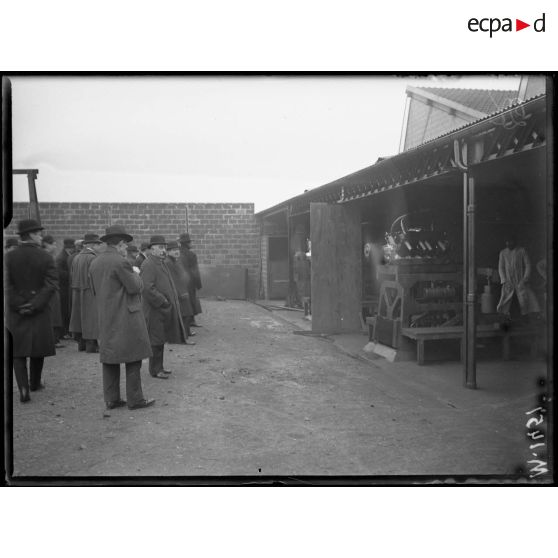 Bois Colombes, usines Hispano Suiza. Les journalistes regardent fonctionner des moteurs d'avions testés sur des bancs d'essais (spa 60 m 1451). Un ingénieur de la firme automobile exxplique ensuite aux journaliste le fonctionnement du moteur (spa 60 m 1452). [légende d'origine]