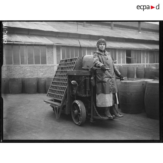 Usines Citroën du quai de Javel. Femme conduisant un chariot électrique servant au transport des obus. [légende d'origine]