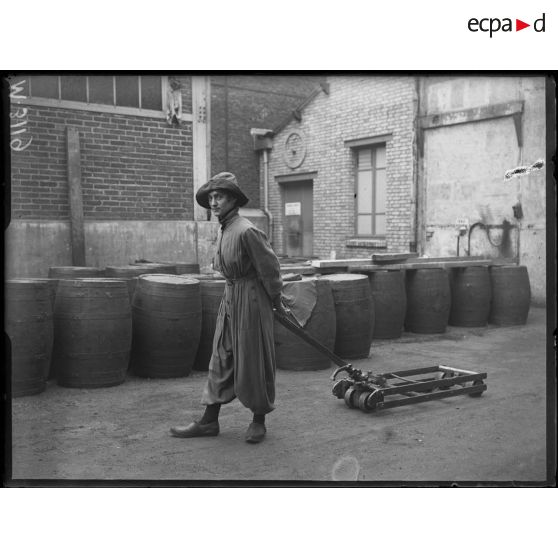 Usines Citroën du quai de Javel. Femme en culotte traînant un petit chariot. [légende d'origine]