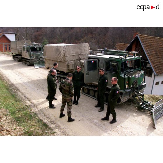 Les sergents Texier et Garin et les caporaux-chefs Avet et Laguerre au bord de la route devant les véhicule à chenilles (VAC).