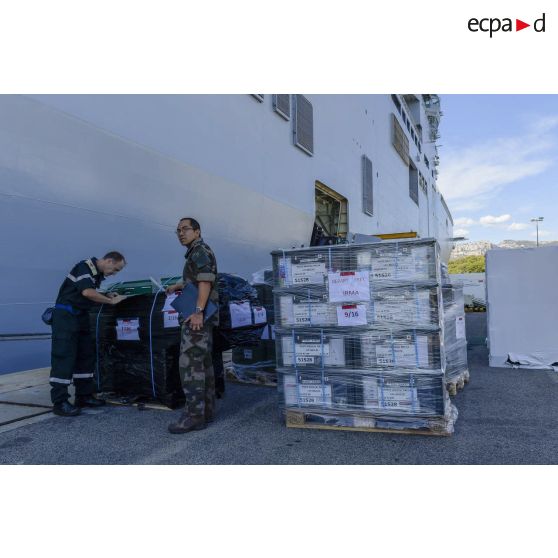 Un chirurgien-dentiste en chef secondé d'un major prend en compte le matériel médical à charger à bord du bâtiment de projection et de commandement (BPC) Le Tonnerre  à Toulon.