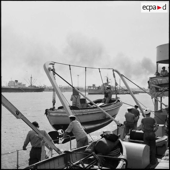 La mise à flot d'une vedette de l'aviso-escorteur "Marcel Le Bihan", bâtiment - base de direction de port, pour le débarquement de l'EMFA (Etat-major de la Force A ?).