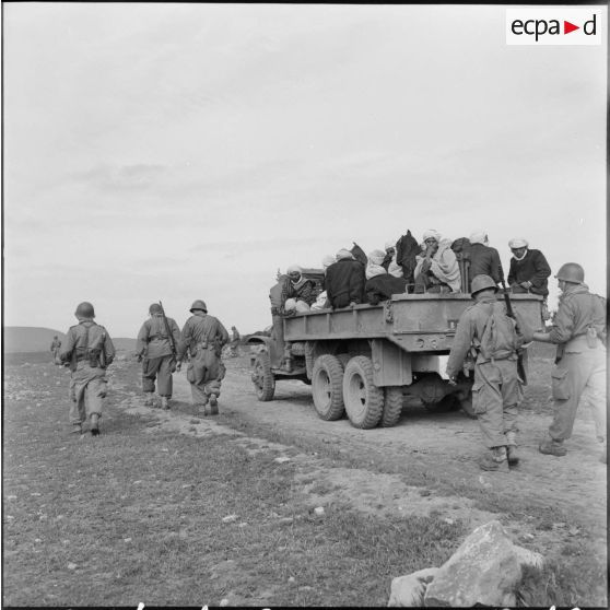 Région d'El Gor. Des hommes sont transportés en camion vers le poste, accompagnés par des militaires.