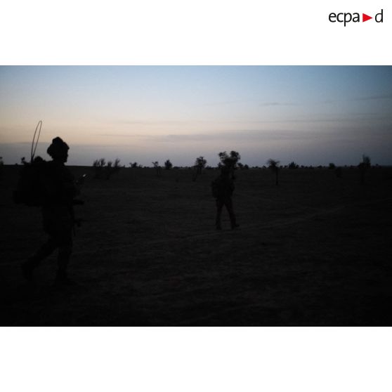 Un groupe de soldats entame une progression en direction d'un village au lever du soleil dans le Gourma malien.