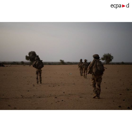 Un groupe de soldats entame une progression en direction d'un village au lever du soleil dans le Gourma malien.