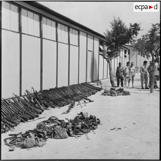 Région de Tebessa. Vue d'ensemble des armes saisies et déposées contre un mur.