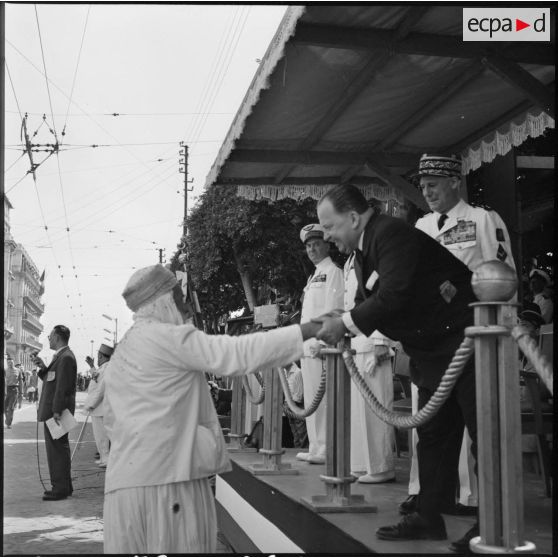 Cérémonie du 14 juillet à Alger. Un ancien combattant musulman serre la main de Robert Lacoste.