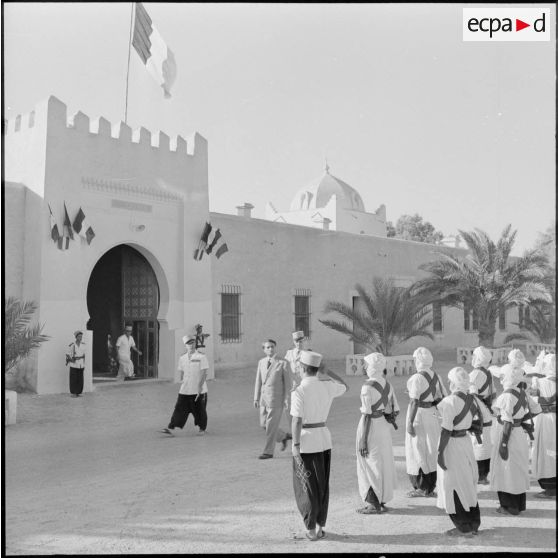 Max Lejeune, ministre du Sahara, le général Quenard, commandant les troupes et services des territoires du sud, et le colonel Darcimolle, commandant le territoire des oasis, passant en revue un détachement des Compagnies sahariennes devant le bordj Luteau à Ouargla.