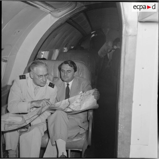 Max Lejeune, ministre du Sahara, et le général Quenard, commandant les troupes et services des territoires du sud, consultant la carte dans l'avion ministériel qui les ramène à Tamanrasset.