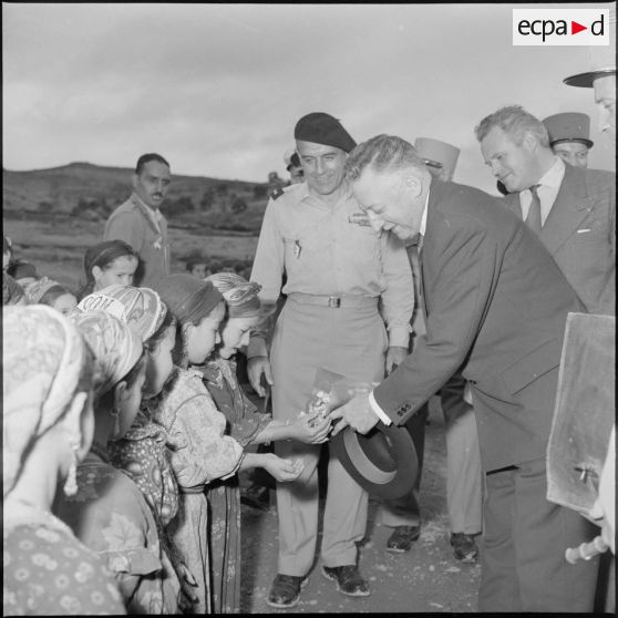 André Morice, ministre de la Défense nationale et des Forces armées, distribue des bonbons aux enfants de Boudjima.