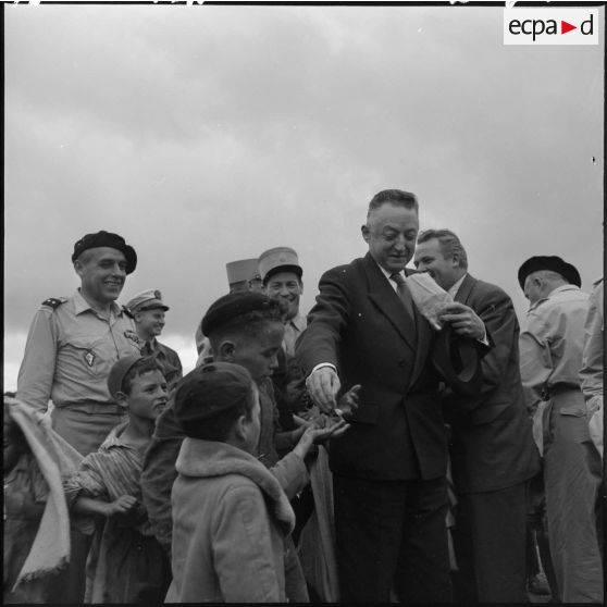 André Morice, ministre de la Défense nationale et des Forces armées, distribue des bonbons aux enfants de Boudjima.