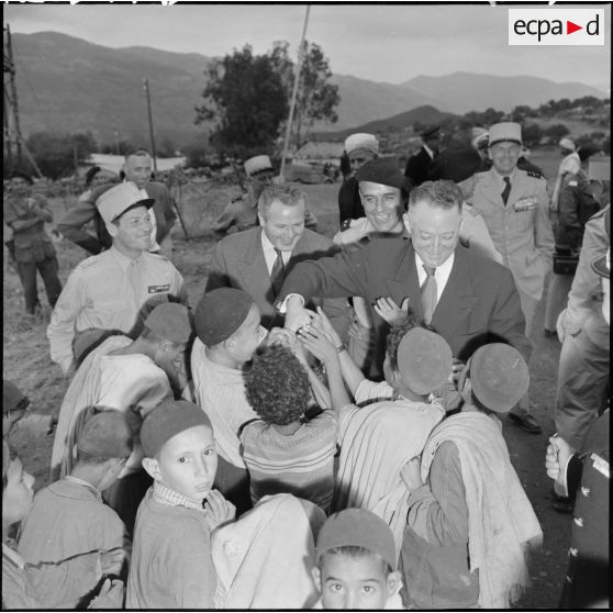 André Morice, ministre de la Défense nationale et des Forces armées, distribue des bonbons aux enfants de Boudjima.