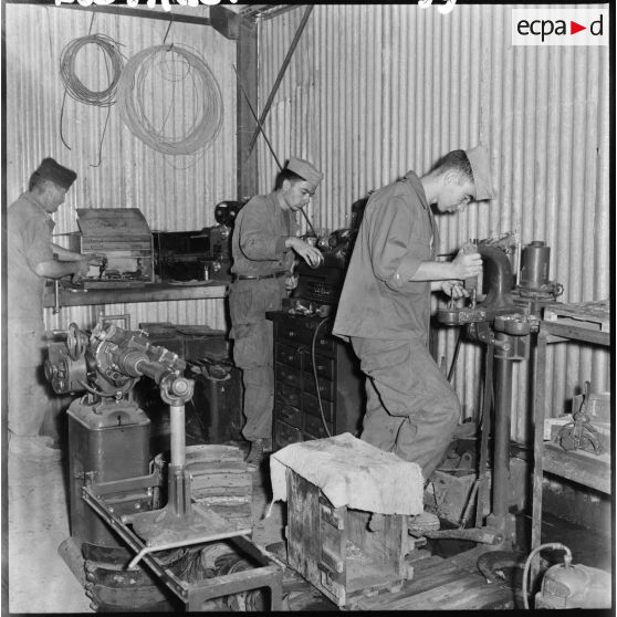 Des soldats de la 407ème compagnie de réparation divisionnaire (CRD) travaillent sur des machines dans l'atelier.