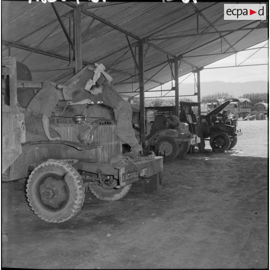 Des soldats de la 407ème compagnie de réparation divisionnaire (CRD) travaillent sur des camions dans l'atelier.