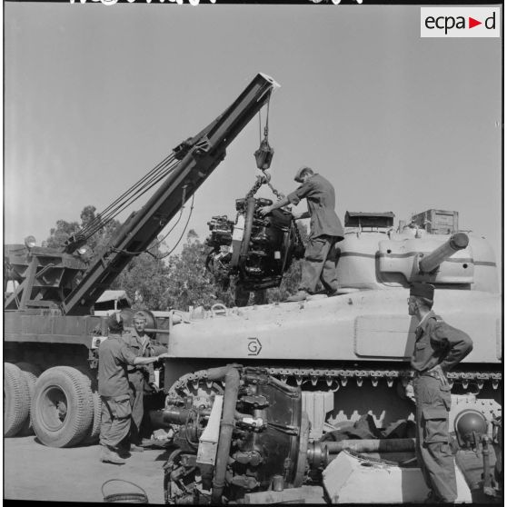 Des soldats de la 407ème compagnie de réparation divisionnaire (CRD) travaillent sur un char M4 Sherman (US).