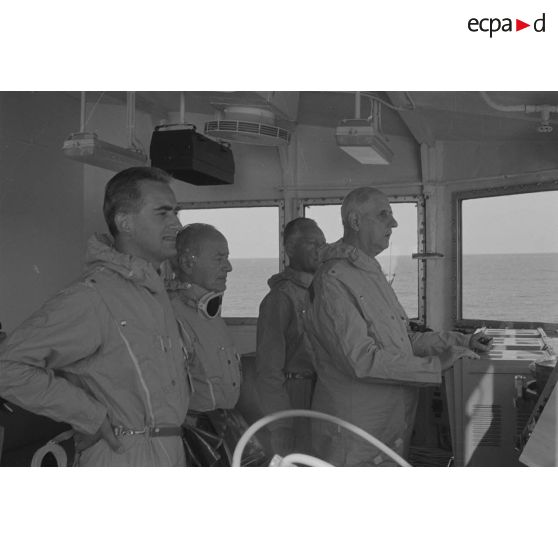 Le général de Gaulle en tenue de protection à bord du croiseur de commandement De Grasse lors du déclenchement de l'essai nucléaire Bételgeuse sur l'atoll de Moruroa.