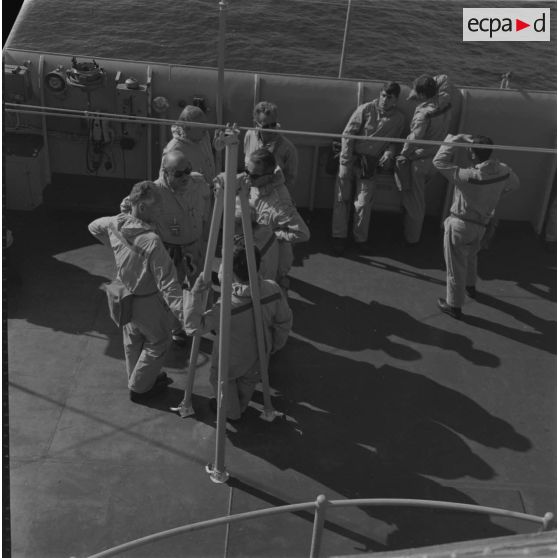 Portrait de groupe des autorités en tenue de protection à bord du croiseur de commandement De Grasse lors du déclenchement de l'essai nucléaire Bételgeuse sur l'atoll de Moruroa.