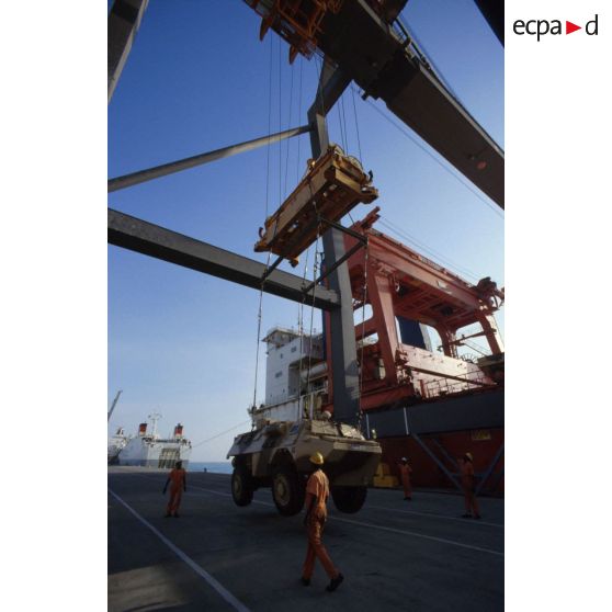 Déchargement d'un VAB à l'aide d'une grue par des ouvriers dockers locaux sur le quai du port de Yanbu.