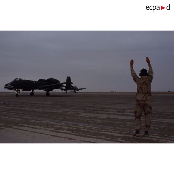 Un mécanicien de piste américain guide un avion d'appui rapproché Fairchild A-10 Thunderbolt-II au roulage sur la piste de la base air américaine de CRK (camp du roi Khaled).