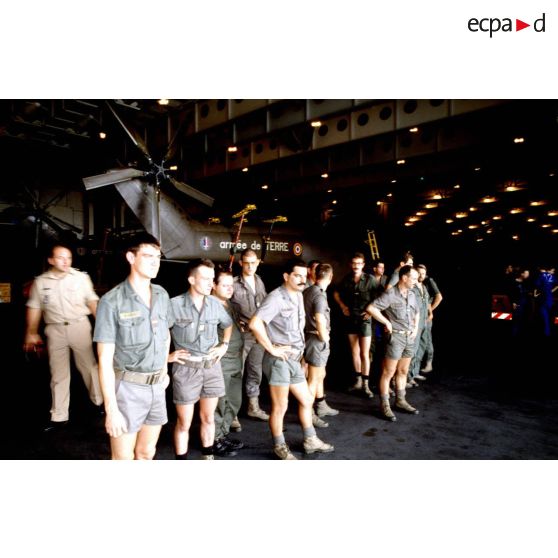 Personnels du 5e RHC dans le hangar du PA (porte-avions) Clemenceau, devant un hélicoptère de transport Puma.