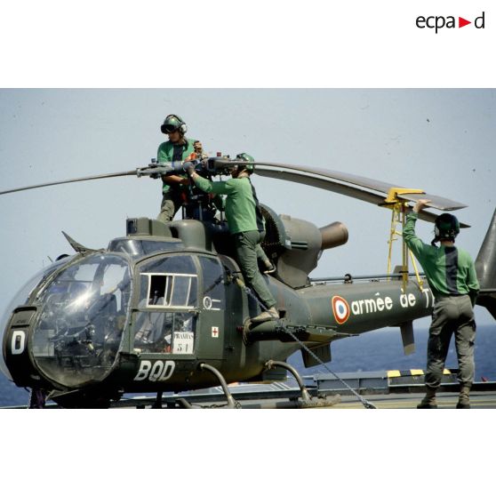 Personnel de pont du PA (porte-avions) Clemenceau pliant les pales d'un hélicoptère de combat Gazelle du 5e RHC sur le pont du PA (porte-avions) Clemenceau.