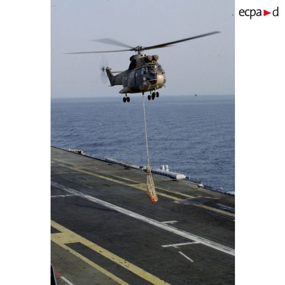 Exercice de transport sous élingue par un hélicoptère de transport Puma au-dessus du PA (porte-avions) Clemenceau.