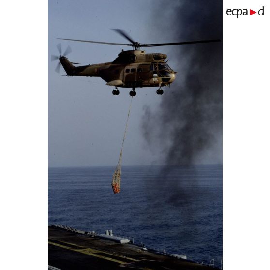 Exercice de transport sous élingue par un hélicoptère de transport Puma au-dessus du PA (porte-avions) Clemenceau.