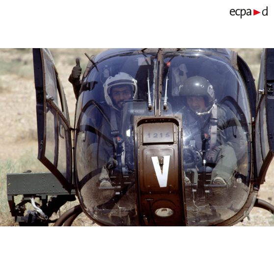 Pilote émirati et pilote français dans le cockpit d'un hélicoptère de combat Gazelle de l'ALAT (aviation légère de l'armée de terre).