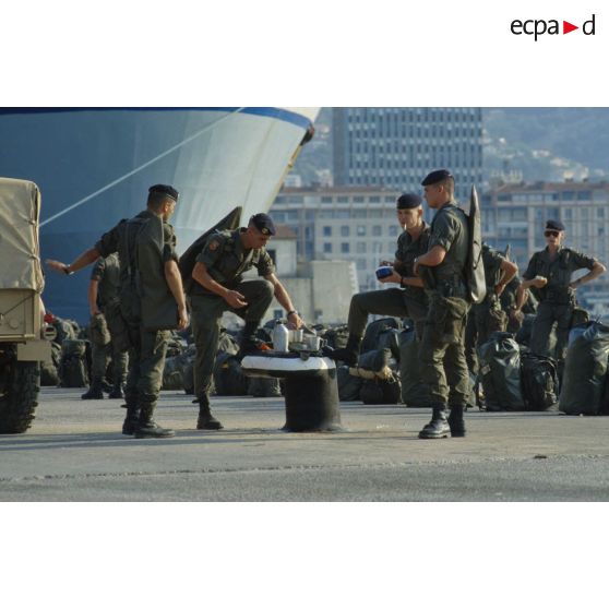 Les soldats du 1er RS prennent leur petit déjeuner sur le quai d'embarquement.