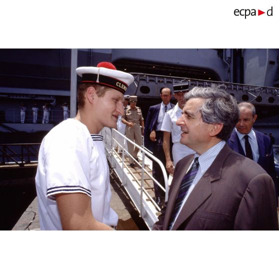 Jean-Pierre Chevènement, ministre de la Défense, en conversation avec un marin du PA (porte-avions) Clemenceau, sur le quai à Djibouti.