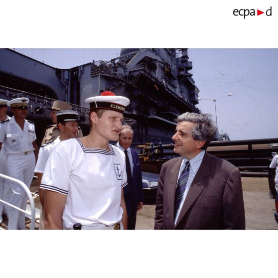 Jean-Pierre Chevènement, ministre de la Défense, en conversation avec un marin du PA (porte-avions) Clemenceau, sur le quai à Djibouti.