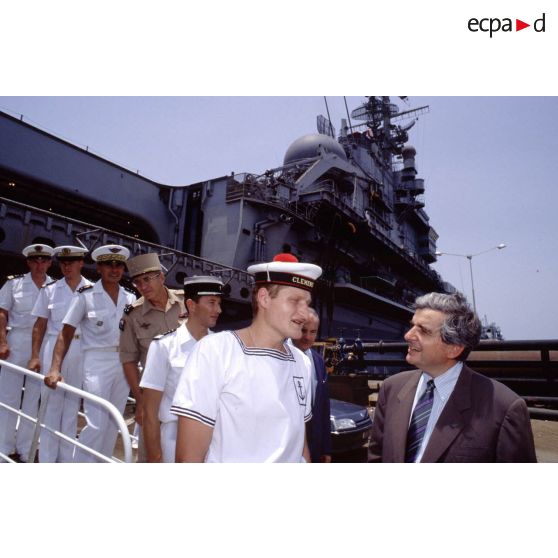 Jean-Pierre Chevènement, ministre de la Défense, en conversation avec un marin du PA (porte-avions) Clemenceau, sur le quai à Djibouti.