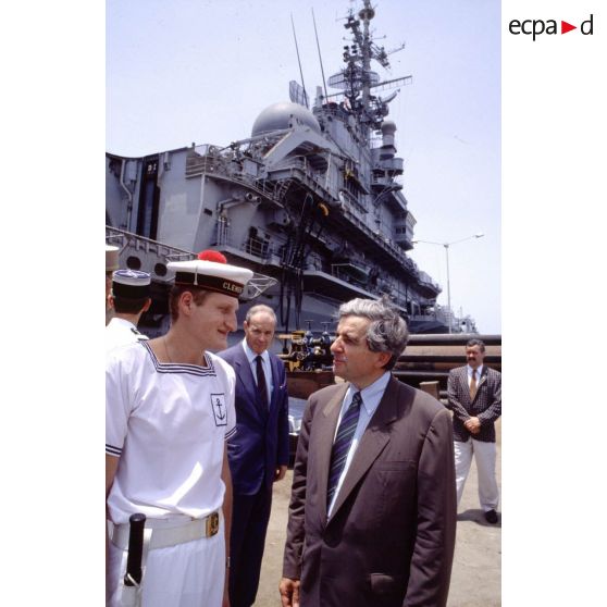 Jean-Pierre Chevènement, ministre de la Défense, en conversation avec un marin du PA (porte-avions) Clemenceau, sur le quai à Djibouti.