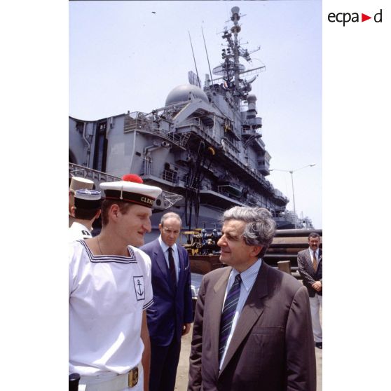 Jean-Pierre Chevènement, ministre de la Défense, en conversation avec un marin du PA (porte-avions) Clemenceau, sur le quai à Djibouti.