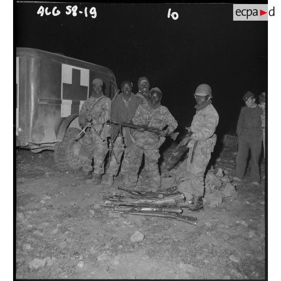 Soldats posant devant les armes récupérées aux fellaghas lors d’une opération héliportée sur le djebel Tarf.