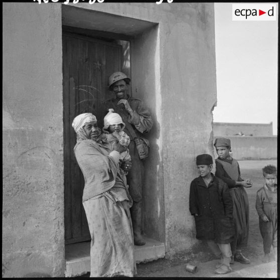 Habitants de la cité ouvrière de Béchar Djedid devant leur maison.