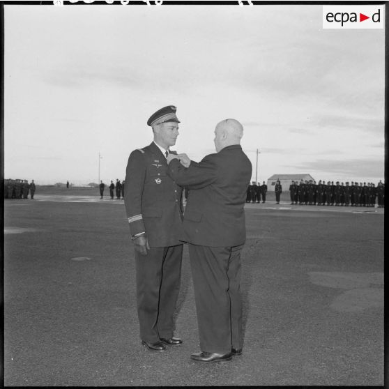 Remise de la médaille de l’aéronautique par Louis Christiaens, secrétaire d’État aux forces armées de l'Air, à un commandant sur la base aérienne de Colomb-Béchar.