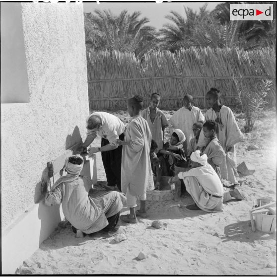 Les élèves et le maître d’école travaillent du bois dans la cour de l’école de Djanet.