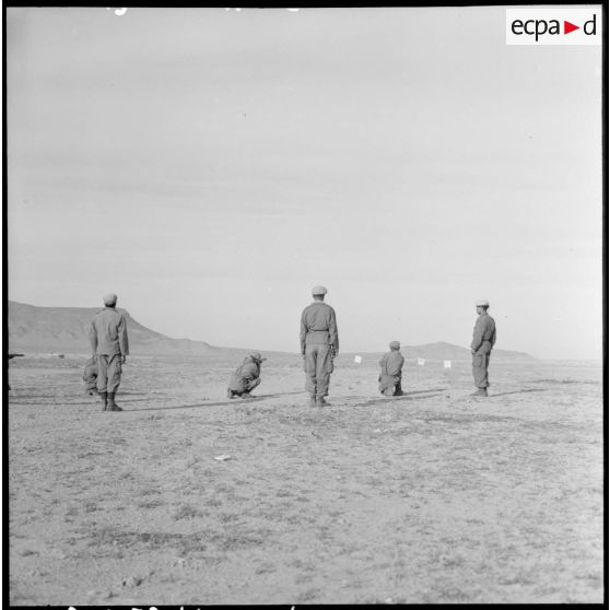 Un groupe d’hommes s’entraîne à tirer au fusil sur le champ de tir de Bou-Saâda.