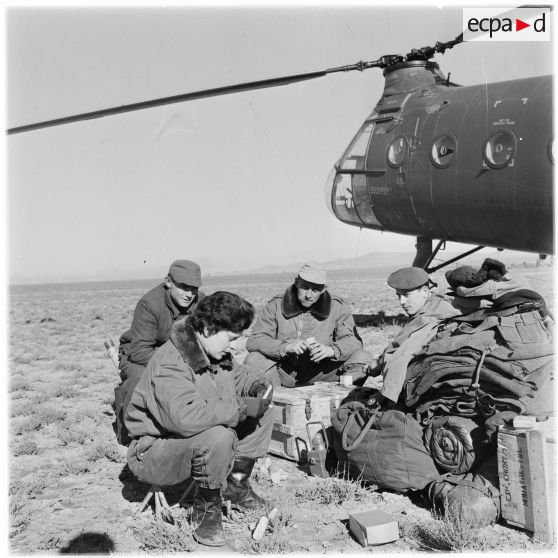 Un groupe de parachutistes devant leur hélicoptère.