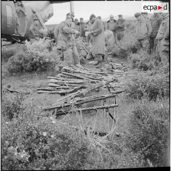 L'armement récupéré est déchargé et compté sur le terrain des hélicoptères bananes Piasecki H-21.