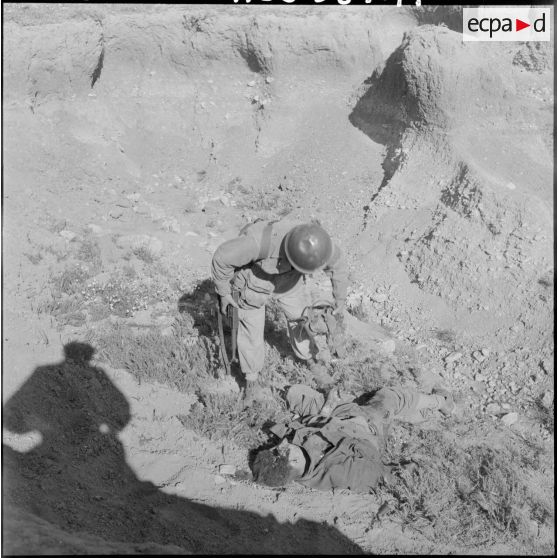 Un soldat du 81ème régiment d'infanterie (RI) près du corps du fellaga qu'il vient de tuer.