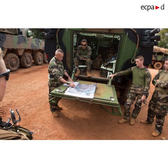 Deux soldats du GTIA (groupement tactique interarmes) Vercors réparent un pneu dans un container, au train de combat du camp M'Poko de Bangui.